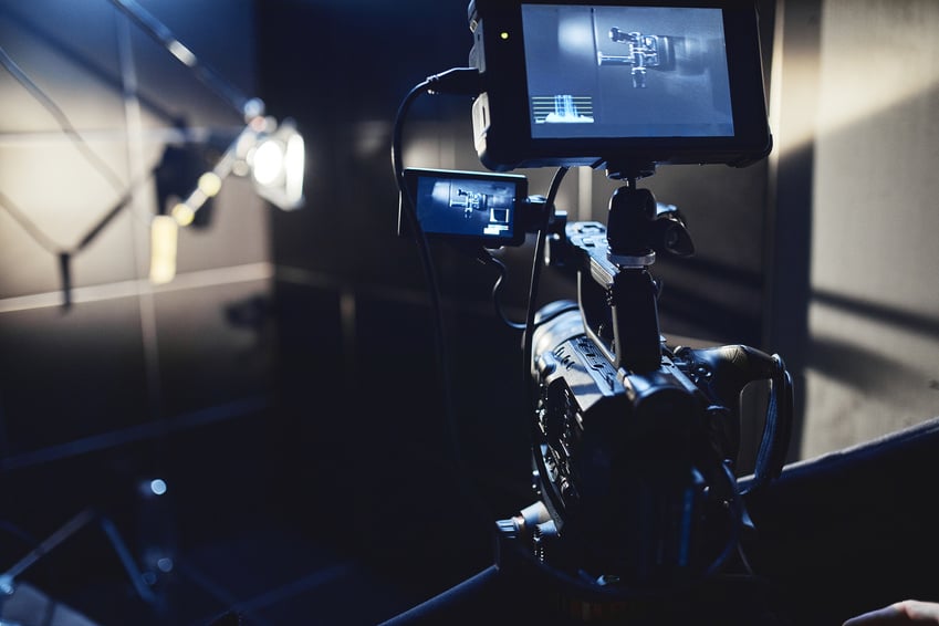 Video production backstage. Behind the scenes of creating video content, a professional team of cameramen with a director filming commercial ads. Video content creation, video creation industry. Low key, selective focus, film graine